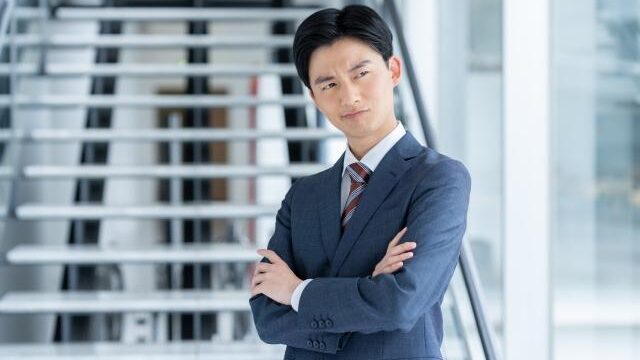 建物の前に立っているスーツを着た男性  AI によって生成されたコンテンツは間違っている可能性があります。
